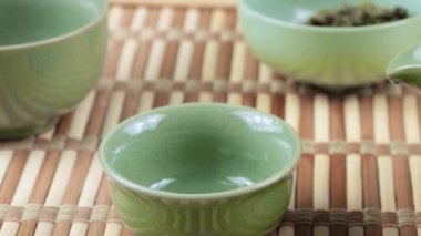 İyileştirilmiş çay yaprakları sıcak seramik gaivanlara dökülür. Doğu Asya tarzı çay töreni.