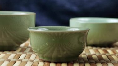 Seramik chawanları bir gaiwan 'dan gelen sıcak suyla ısıtıyorum. Doğu Asya tarzı çay seremonisi.