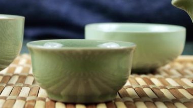 Gaiwan 'dan seramik chawanlara yeşil çay dökülüyor. Doğu Asya tarzı çay seremonisi.