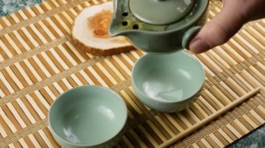 Gaiwan 'dan seramik chawanlara yeşil çay dökülüyor. Doğu Asya tarzı çay seremonisi. Üst görünüm.
