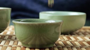 Gaiwan 'dan seramik chawanlara yeşil çay dökülüyor. Doğu Asya tarzı çay seremonisi.