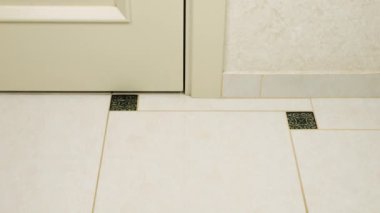 Erkek pantolonu fayanslı zemine atılır. Çamaşır yıkama, kıyafet düzenleme ve evi temizleme teması..
