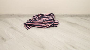 Parlak renkli kadın kıyafetleri odanın zeminine atılır. Çamaşır yıkama, kıyafet düzenleme ve evi temizleme teması..