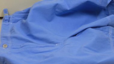 Beyaz ve mavi renkli yaz kadın kıyafetleri fayanslı zemine atılır. Çamaşır yıkama, kıyafet düzenleme ve evi temizleme teması..