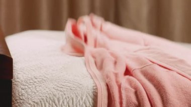 Kadın kıyafetleri, sweatshirt, kazak, kot pantolon, pantolon ve uzun kollar yatağa atılır..