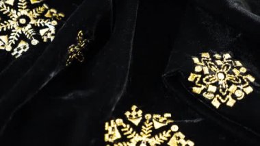Altın işlemeli, gösterişli siyah ipek kumaş kadife kumaş. Tekstil arka planında üst görünüm. Tema tasarımı, moda, terzilik ve aksesuarlar. Güzel kıvrımlı kumaş