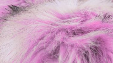 Magenta pembe renkli sahte kürk, uzun bir yığın, tilki kürkü taklidi, dönen vitrinde kutup tilkisi. Moda, tasarım, doğa ve hayvan koruma teması üzerine arka plan. Yakın çekim görünümü.