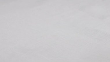 Beyaz keten kumaş vitrinde dönüyor. Tekstil arka planının üst görüntüsü. Tema tasarımı, moda, kıyafet terziliği.