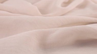 Dönen bir vitrin üzerinde ince yumuşak ışık cameo pembe şifon kumaşının yumuşak kıvrımlarının yakın görüntüsü. Moda, tasarım, kumaş teması üzerine aksesuar dikebilen tekstil arka planı.