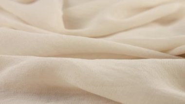 Dönen vitrindeki ince pembe tuz beyaz şifon kumaşının yumuşak kıvrımlarının yakın çekim görüntüsü. Moda, tasarım, kumaş teması üzerine aksesuar dikebilen tekstil arka planı.
