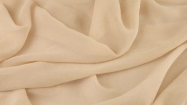 Dönen bir vitrin üzerinde ince deniz kabuğu beyaz şifon kumaşının yumuşak kıvrımlarının üst görüntüsü. Moda temalı dikiş aksesuarları ile tekstil arka planı.