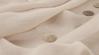İnce pembe tuz beyaz şifon kumaş rengi şifon ve vitrindeki doğal inci düğmelerin üst görüntüsü. Moda temalı dikiş aksesuarları ile tekstil arka planı.