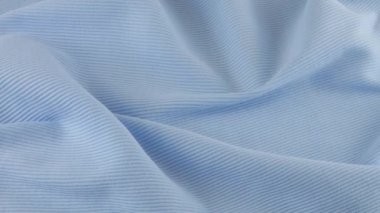 İnce, koyu mavi pamuklu formanın yumuşak kıvrımlarının üst görüntüsü. Tekstil arka planı vitrinde döner. Moda, tasarım, doğal kumaş teması üzerine arka plan.