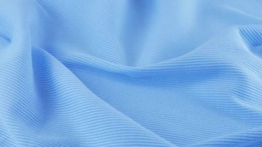 İnce shazam mavi pamuk formanın yumuşak kıvrımlarının üst görüntüsü. Tekstil arka planı vitrinde döner. Moda, tasarım, doğal kumaş teması üzerine arka plan.