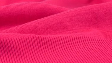 Pembe pamuklu forma fuschia tonunun yakın çekim görüntüsü. Katlanan tekstil arka planı vitrin üzerinde döner. Moda, tasarım, doğal kumaş teması üzerine arka plan.