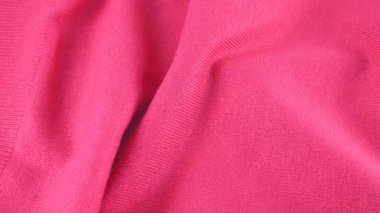 Pembe renkli pamuklu forma, sakız tonu. Katlanan tekstil arka planı vitrin üzerinde döner. Moda, tasarım, doğal kumaş teması üzerine arka plan.