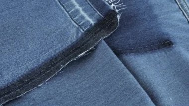 Mavi kotun yumuşak kıvrımlı gölgeli kumaşı vitrinde dönüyor. Yeniden kullanım teması, giysi geri dönüşümü ve çevreyi korumak amacıyla tekstil arka planı.