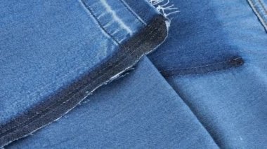 Parlak mavi renkli kumaşın yumuşak kıvrımları vitrinde dönüyor. Yeniden kullanım, geri dönüşüm giysileri ve tekstil teması üzerine tekstil arka planı.