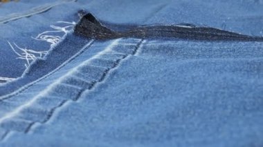 Açık mavi kot kumaşın yumuşak kıvrımları vitrinde dönüyor. Tasarım, moda, doğal kumaşların rahat giyiminin terziliği. Tekstil arkaplanı.
