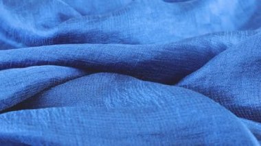 Vitrinde dönen koyu mavi ipek kumaşın yumuşak kıvrımlarında yakın çekim görüntüsü. Moda, tasarım, aksesuarlar konularında tekstil arka planı.