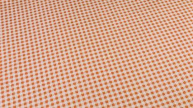 Tozlu pembe ve beyaz kafes kumaşının üst görüntüsü vitrinde döndürüldü. Tasarım teması, zanaat, el yapımı, yama çalışması, yaratıcılık teması.