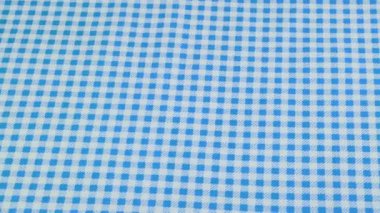 Açık mavi ve beyaz kafes kumaşının üst görüntüsü vitrinde döndürüldü. Tasarım teması, zanaat, el yapımı, yama çalışması, yaratıcılık teması.