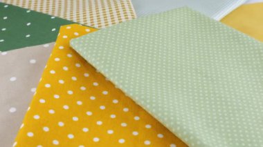 Puantiyeli pamuk kumaş şeritlerinin üst görüntüsü polka noktasında ve vitrinde döndürülmüş. Tasarım teması, zanaat, el yapımı, yama çalışması, yaratıcılık teması.