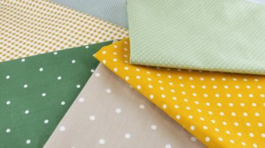 Puantiyeli pamuk kumaş şeritlerinin üst görüntüsü polka noktasında ve vitrinde döndürülmüş. Tasarım teması, zanaat, el yapımı, yama çalışması, yaratıcılık teması.