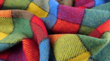 Parlak desenli çok renkli kumaşın yumuşak kıvrımlarının üst görünümü vitrinde döndürüldü. Soğuk hava, sıcak kıyafetler, konfor, aksesuarlar ve tasarım teması üzerine tekstil arka planı.