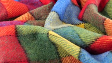 Parlak desenli çok renkli kumaşın yumuşak kıvrımlarının üst görünümü vitrinde döndürüldü. Soğuk hava, sıcak kıyafetler, konfor, aksesuarlar ve tasarım teması üzerine tekstil arka planı.