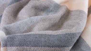 Vitrindeki yumuşak yün kumaş katlarının pastel gri-pembe renklerinin üst görüntüsü. Soğuk hava, sıcak kıyafetler, konfor, aksesuarlar ve tasarım teması üzerine tekstil arka planı.