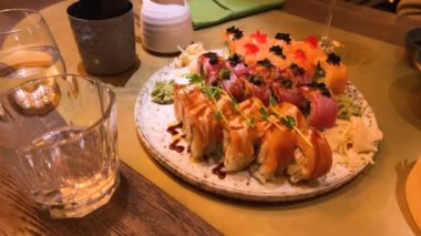 Çeşitli suşiler, börekler ve diğer Asya yemekleri bir restorandaki masada..