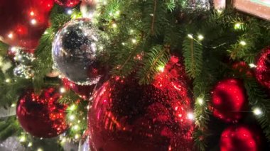 Çelenk ve aydınlatmayla süslenmiş bir Noel ağacının arka planına doğru yağmur yağıyor. Akşamları çekim..