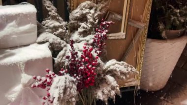 Hediyelik eşya dükkanının girişinin dekoratif unsurları ve dekorasyonları. Kış, kar yağıyor. Noel dekoru, viburum çileği, ikebana buketi.