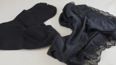 Gri melanjlı kadınların bluzları örülmüş siyah diz çorap ve külotların üzerine düşer. Kadın iç çamaşırı teması.