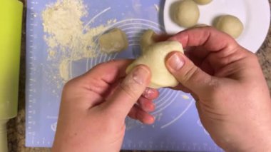 Ham hamurdan yuvarlanan yuvarlak toplar, merdaneyle daha fazla yuvarlanmak için. Üst görünüm.