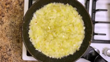 Soğanlar kızartılmış tavada sebze yağında kızartılır. Üst görünüm.