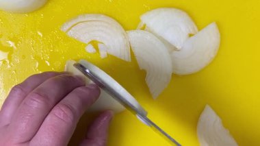 Bıçakla kesme tahtasındaki soğanları yarım halkalara bölmek. Üst görünüm.