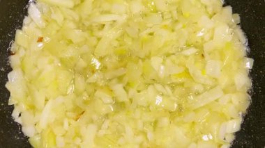 Soğanlar kızartılmış tavada sebze yağında kızartılır. Üst görünüm.