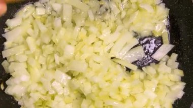 Soğanlar kızartılmış tavada sebze yağında kızartılır. Üst görünüm.