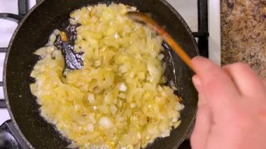 Soğanlar kızartılmış tavada sebze yağında kızartılır. Üst görünüm.