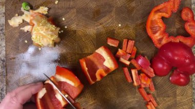 Şef ahşap kesme tahtasındaki bıçakla tatlı biber keser..