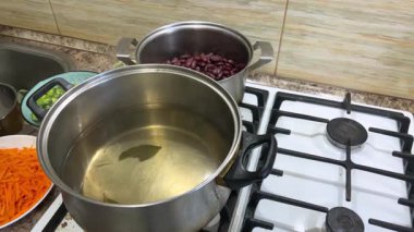 Patatesleri kaynar suyla dolu bir tavaya döküyorum. Ukrayna borşunun pişirilme süreci.