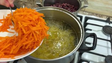 Bir tencereye doğranmış havuç ekliyorum. Ukrayna borsası yapma süreci.