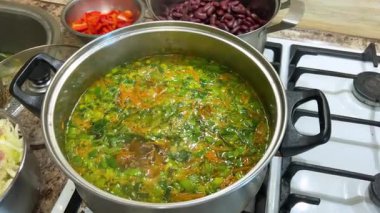 Patates, havuç ve pırasa saplı bir tencereye doğranmış lahana ekliyorum. Ukrayna borsası yapma süreci.