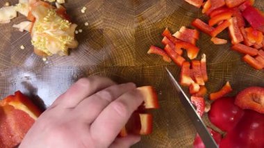 Şef ahşap kesme tahtasındaki bıçakla tatlı biber keser..