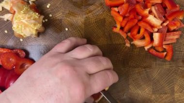 Şef ahşap kesme tahtasındaki bıçakla tatlı biber keser..