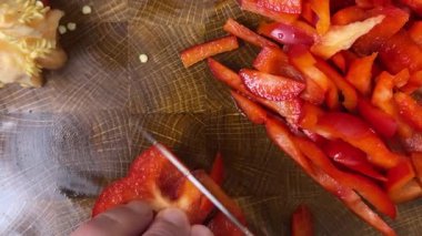 Şef ahşap kesme tahtasındaki bıçakla tatlı biber keser..