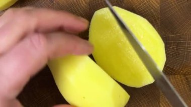 Şef patatesleri tahta kesme tahtasında bıçakla doğruyor..