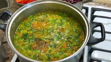 Patates, havuç ve pırasa saplı bir tencereye doğranmış lahana ekliyorum. Ukrayna borsası yapma süreci.